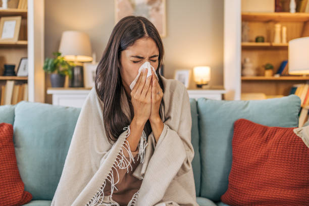 a young woman lying on the sofa in the living room, feeling sick.